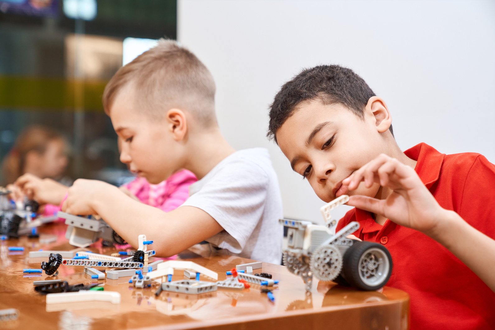 Children creating toys using building kit.